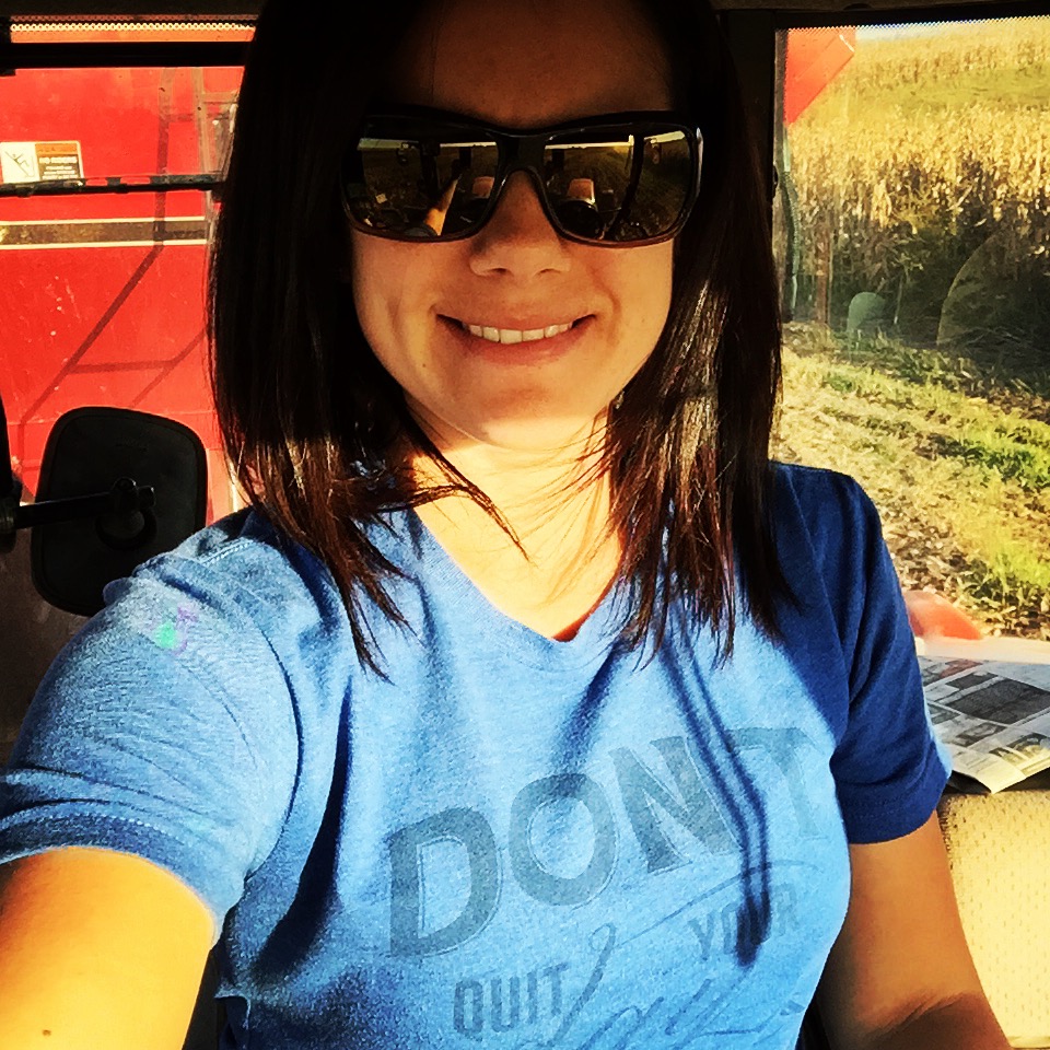 Farmer's wife driving the tractor and grain cart during corn harvest